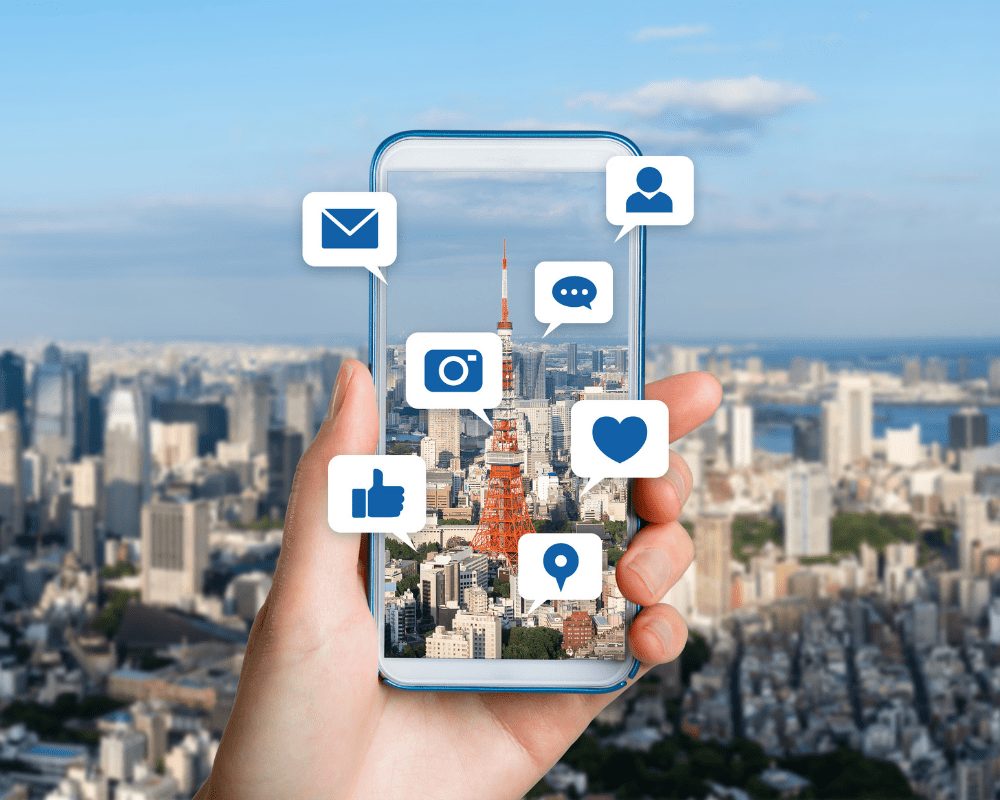 Hand holding phone with social media icons